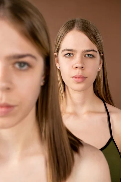 En av tvillingflickorna står bakom sin syster framför kameran — Stockfoto