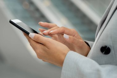 Akıllı telefon ekranına dokunan genç iş kadınının elleri