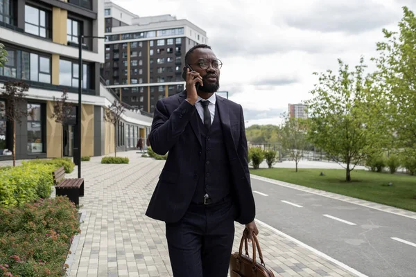 Ocupado banquero de etnicidad africana telefoneando en ambiente urbano — Foto de Stock