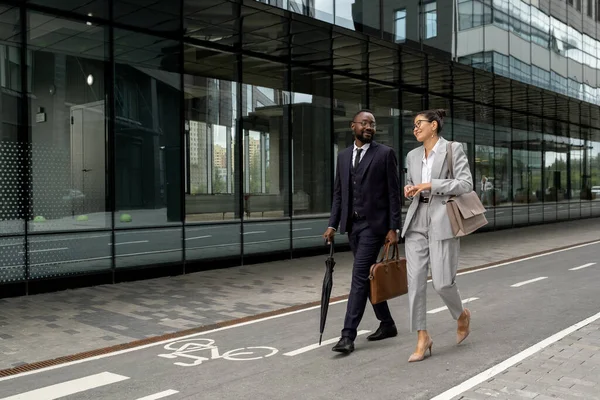 Dos jóvenes colegas interculturales felices caminando por la calle moderna —  Fotos de Stock
