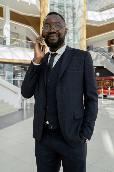 Mladý dobře oblečený muž africké národnosti mluví na mobilním telefonu — Stock fotografie