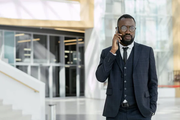 Młody afrykański biznesmen rozmawia przez telefon z kolegą — Zdjęcie stockowe