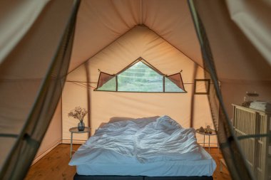 Glamping House 'un yatak odasında çift kişilik yatağı açık.