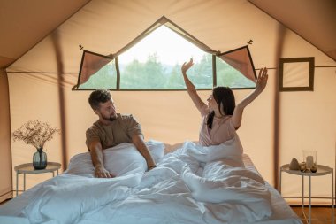 Mutlu genç çift uyandıktan sonra kollarını açıyor.