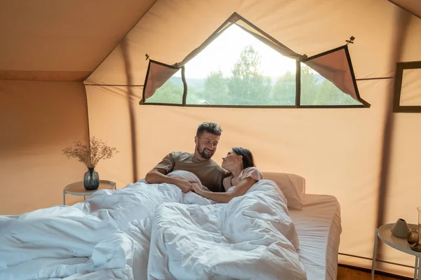 Heureux jeune couple couché au lit après le réveil le matin — Photo