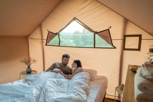 Feliz joven esposo y esposa interactuando en la cama después de dormir —  Fotos de Stock