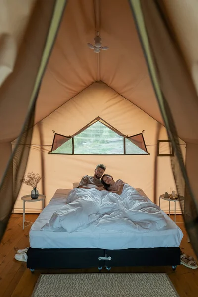 Junges verliebtes Paar ruht sich unter weißer Decke im Bett aus — Stockfoto