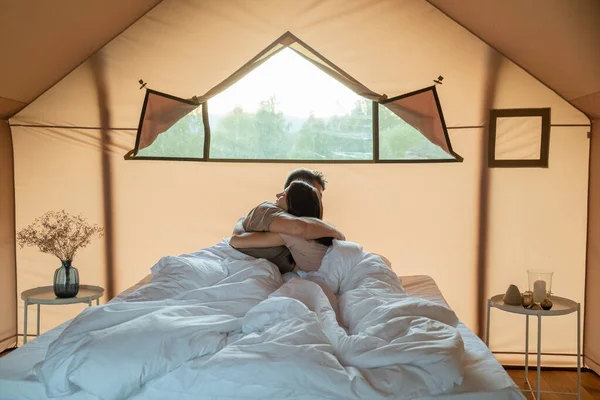 Genç aşık çift uykudan sonra yatakta kucaklaşıyorlar.