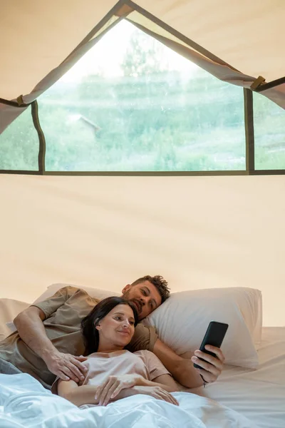 Young restful couple with smartphone making video call — Stock Photo, Image