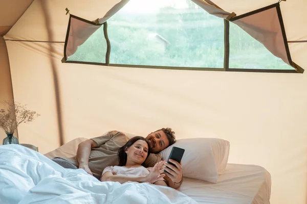 Pareja feliz haciendo selfie o viendo vídeo en el teléfono inteligente — Foto de Stock