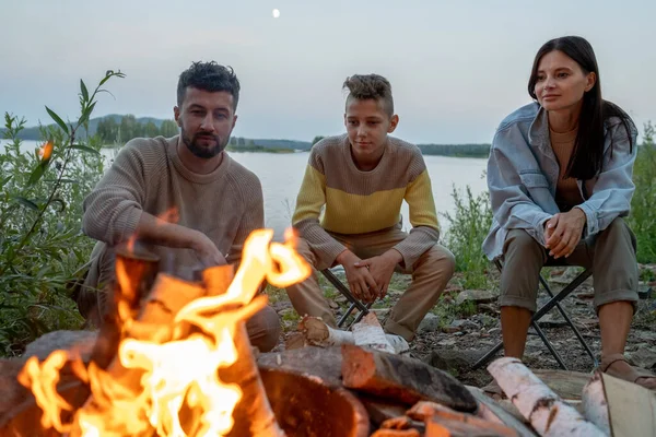 Junge Familie in Freizeitkleidung verbringt Abend am Lagerfeuer — Stockfoto