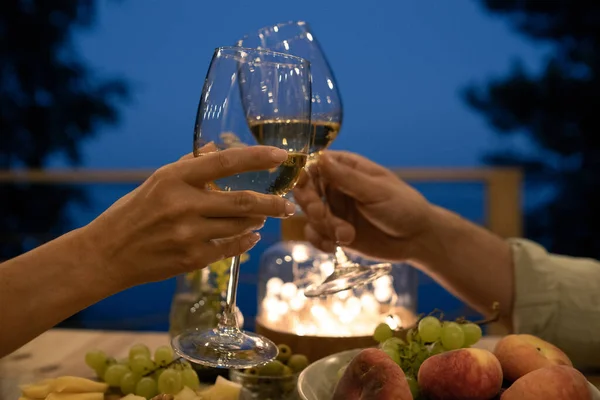 Giovane uomo e donna brindare sul tavolo servito durante la cena romantica — Foto Stock