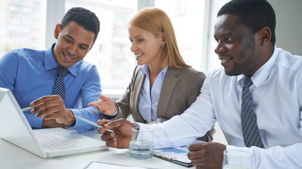 Business partners pointing at laptop — Stock Photo, Image