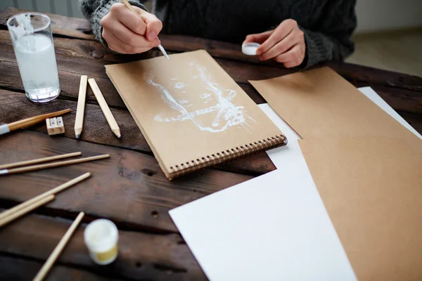 Молодий чоловік малює в блокноті — стокове фото
