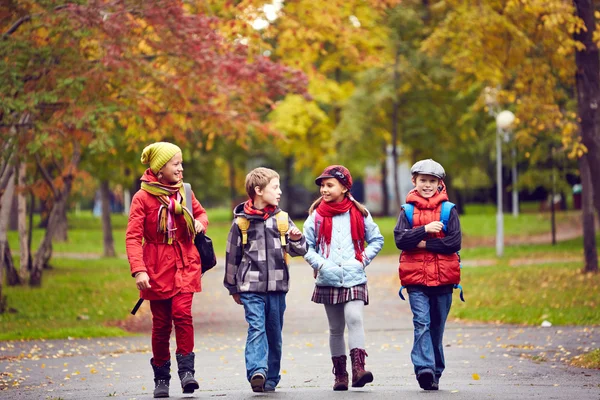 Glad schoolkids talar — Stockfoto