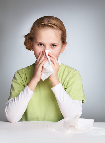 Ill girl blowing her nose