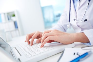 Nurse typing on laptop clipart