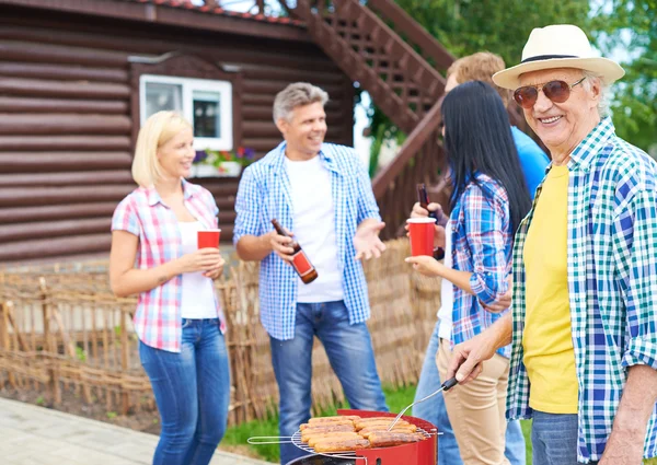 Big family grilling sausages — Stock Photo, Image