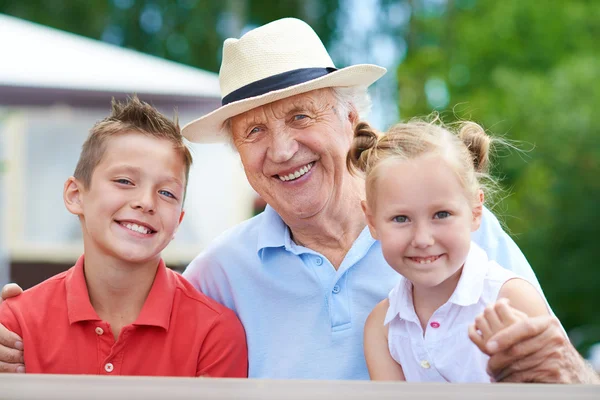 Homme âgé avec deux petits-enfants — Photo