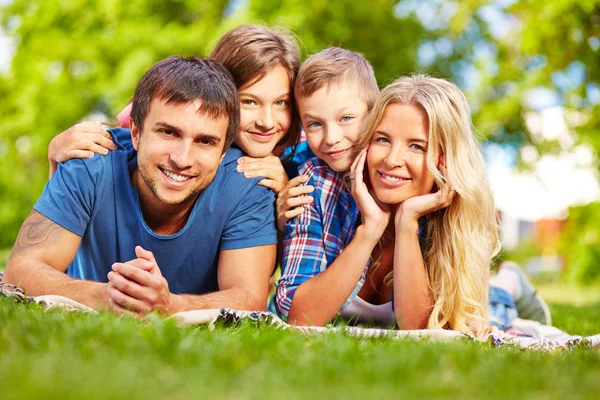 Ontspannen op gras en gelukkige familie — Stockfoto