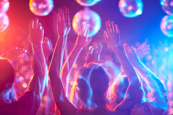 Молодые люди танцуют в ночном клубе