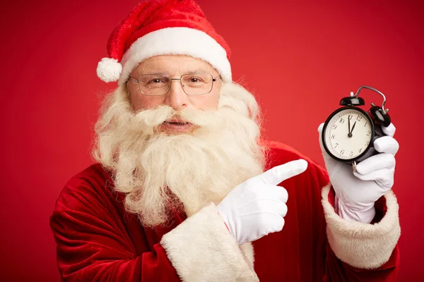 Santa Claus pointing at clock — Stock Photo, Image