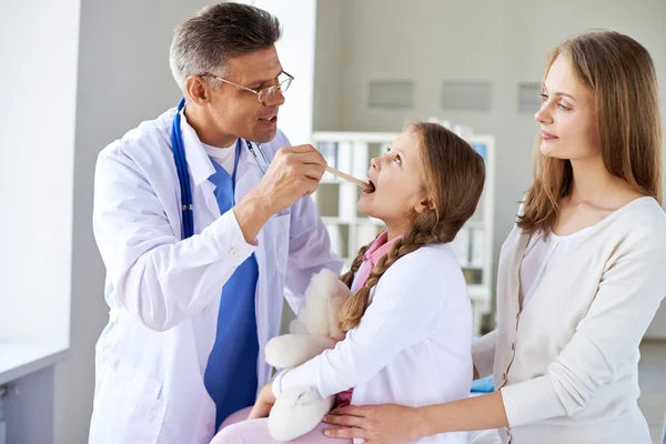 Doctor checking up throat of girl — Stock Photo, Image