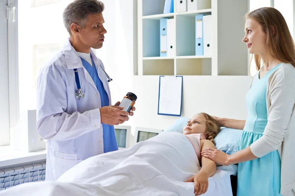 Girl and mother looking at doctor — Stock Photo, Image