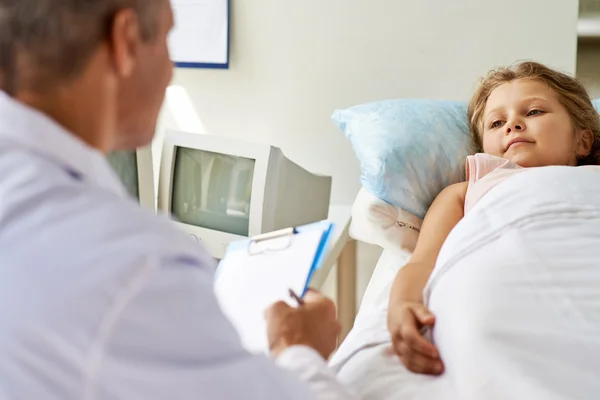 Doce menina olhando para o médico — Fotografia de Stock