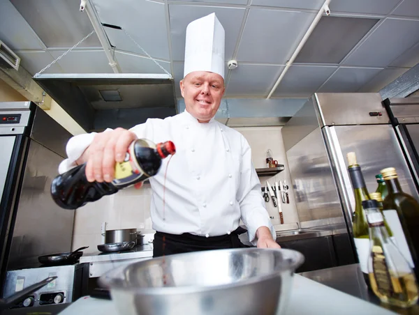 Chefe masculino despejando molho — Fotografia de Stock