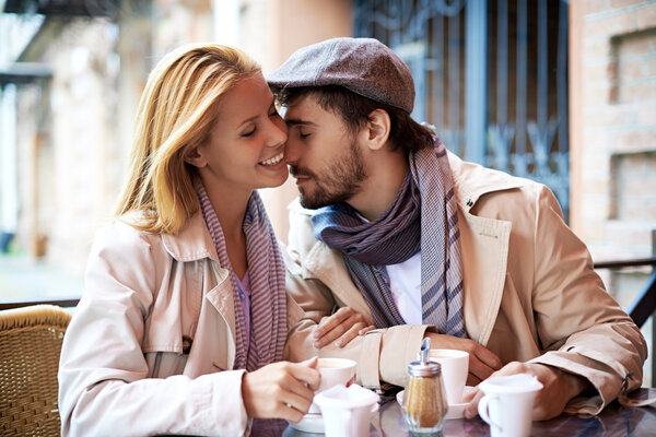 Affectionate couple having coffee in cafe