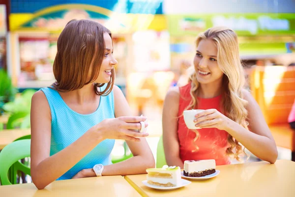 Two girls having cheesecakes with coffee — Stock Photo, Image