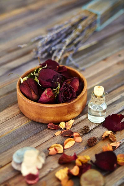 Petals and bottle of aromatic liquid — Stock Photo, Image