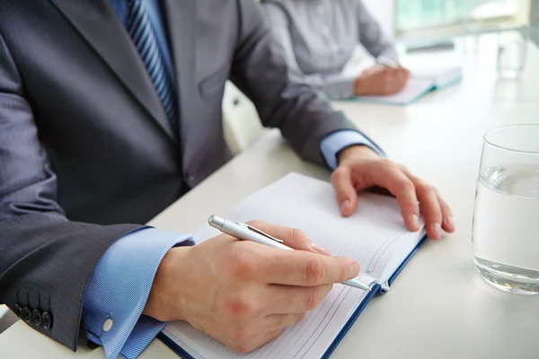 Mannenhand met pen over notitieblok openen — Stockfoto