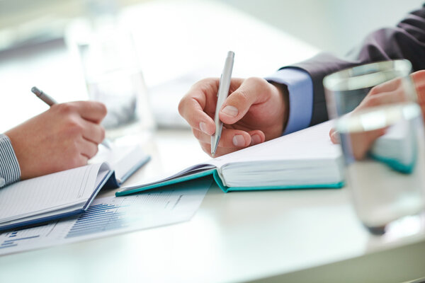 Male and female hands with pens