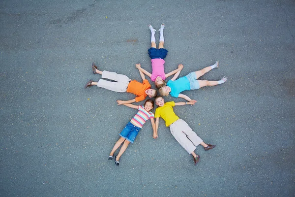 Amigos acostados sobre asfalto cabeza a cabeza —  Fotos de Stock