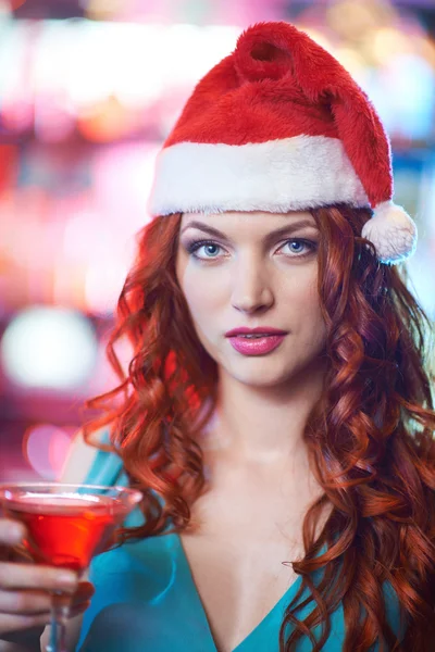 Mädchen in Weihnachtsmannmütze mit einem Glas Martini — Stockfoto