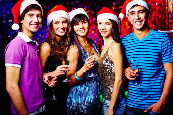 Amigos em bonés Santa brindar na festa — Fotografia de Stock