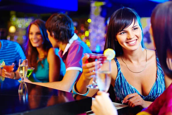 Girl with cocktail talking to her friend — Stock Photo, Image