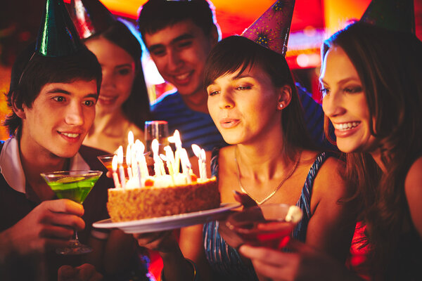 Mujer soplando velas en pastel de cumpleaños — Foto de Stock
