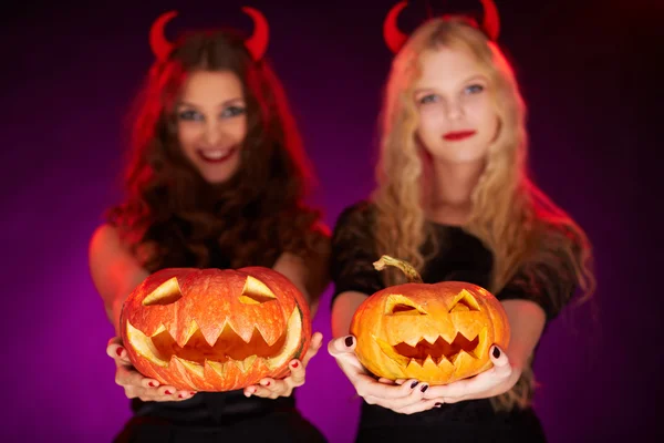Halloween pumpkins held by females — Stock Photo, Image