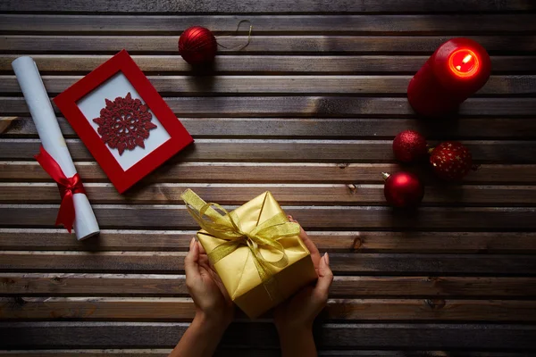 Golden giftbox in female hands — Stock Photo, Image