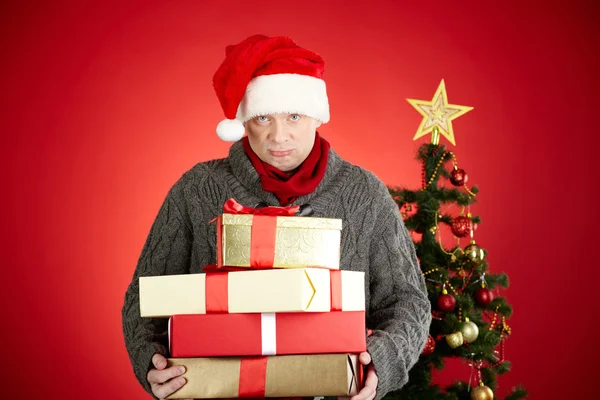 Άνδρας στο καπάκι Santa κρατώντας δώρα — Φωτογραφία Αρχείου