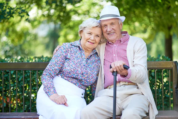 Seniorer som sitter på bänken i park — Stockfoto