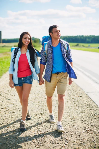 Hitch-excursionistas caminando por la carretera — Foto de Stock