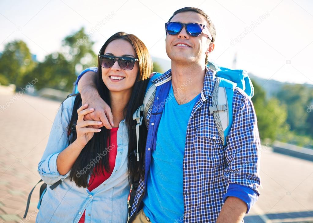 Couple in sunglasses traveling in city