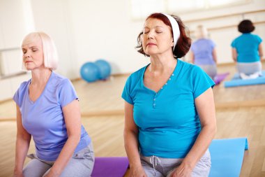 Yaşlı kadın spor salonunda egzersiz yaparak