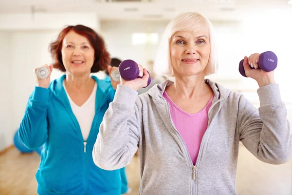 Deportivas haciendo ejercicio con campanas — Foto de Stock