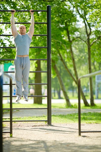 Mens omhoog te trekken inzake de sportuitrusting van de — Stockfoto