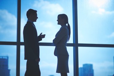 Pencerenin yanında konuşurken iş ortakları